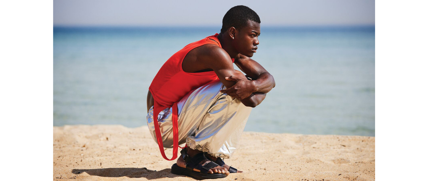 Contemplative man sitting on the beach, symbolizing relaxation and self-care.